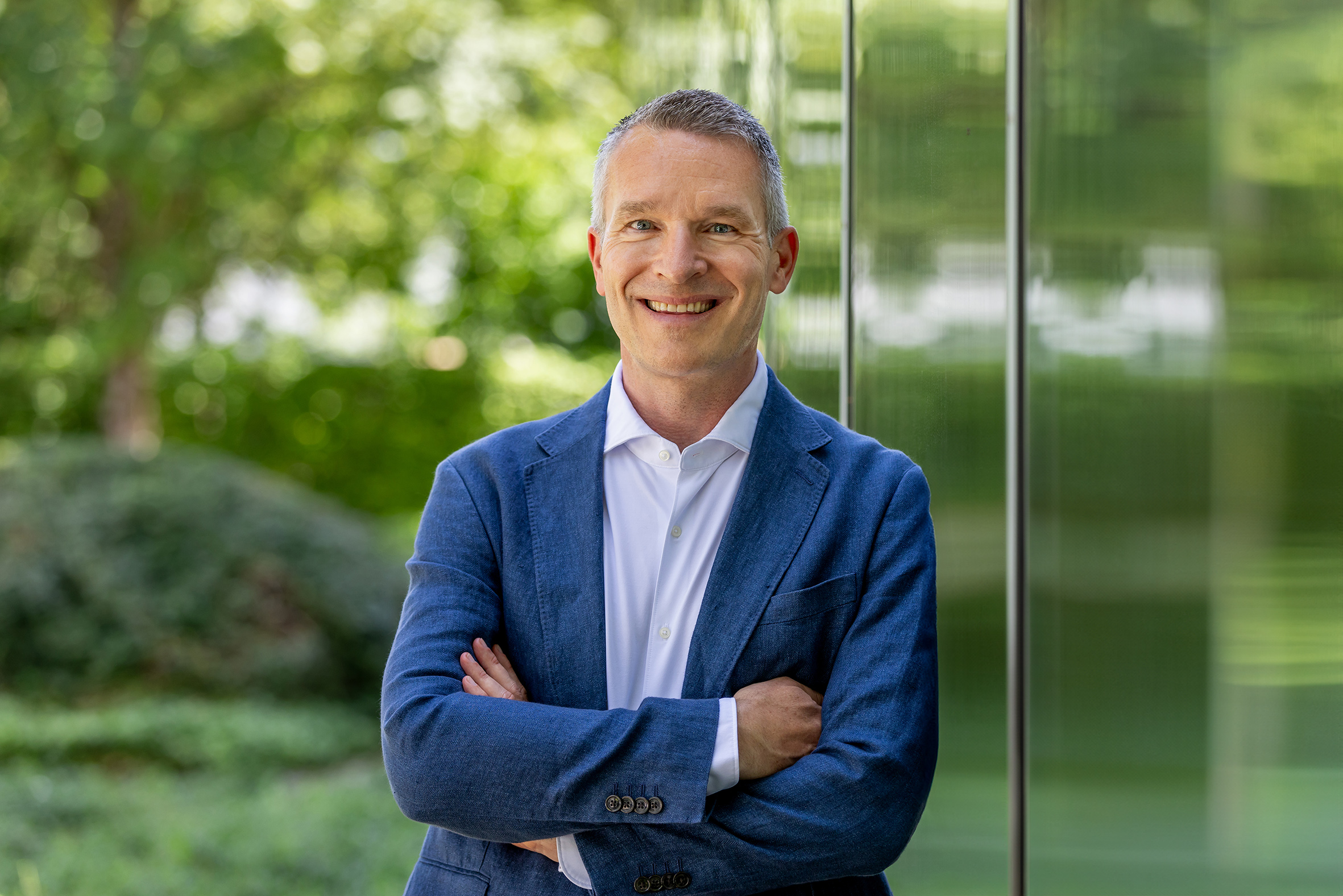 ESB Mitarbeiter vor Glasfenster mit Bäumen im Hintergrund