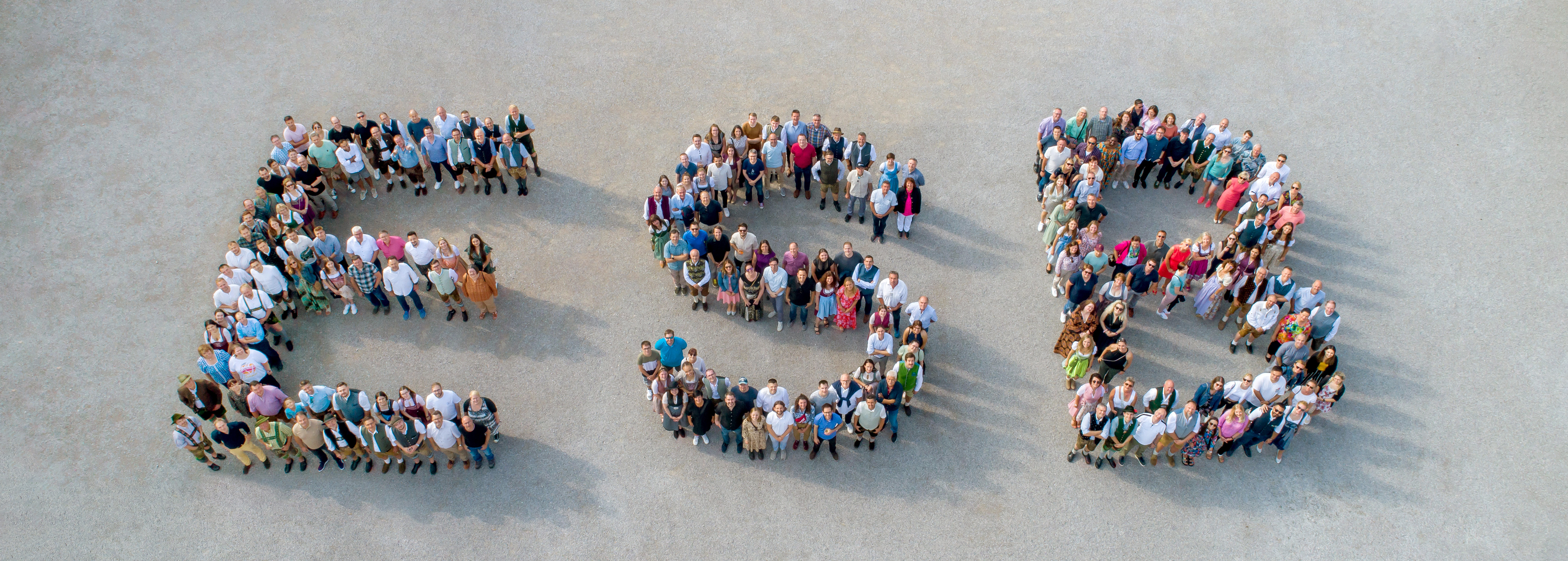 Eine große Gruppe an Menschen bildet die Buchstaben E S B