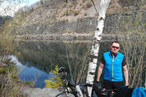 Ein Mann mit Fahrrad vor einem Fluss.