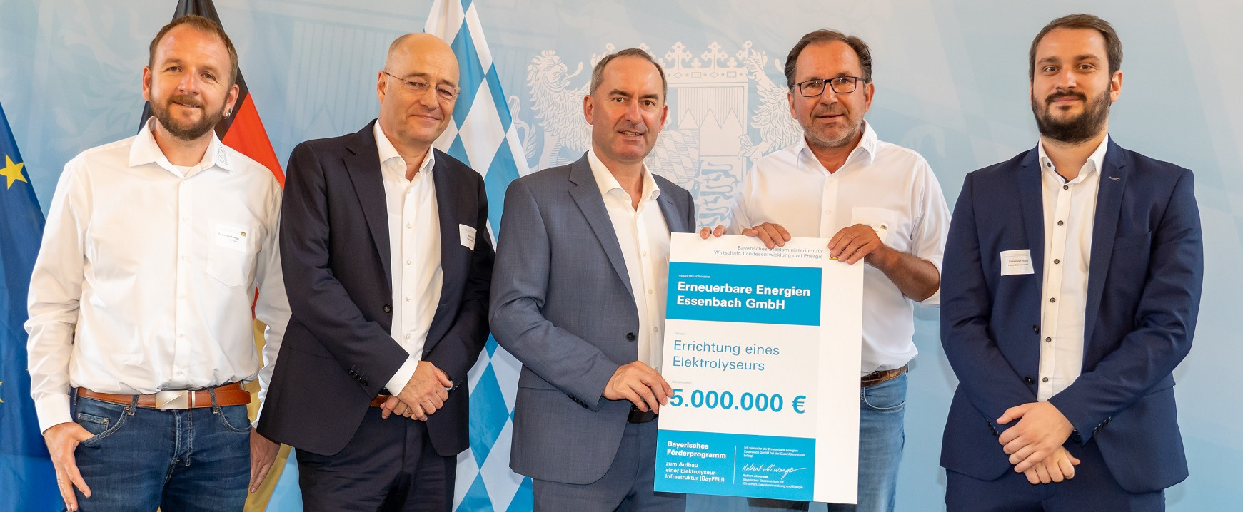Fünf Männer bei der Übergabe des Schecks für ein Elektrolyseurprojekt.