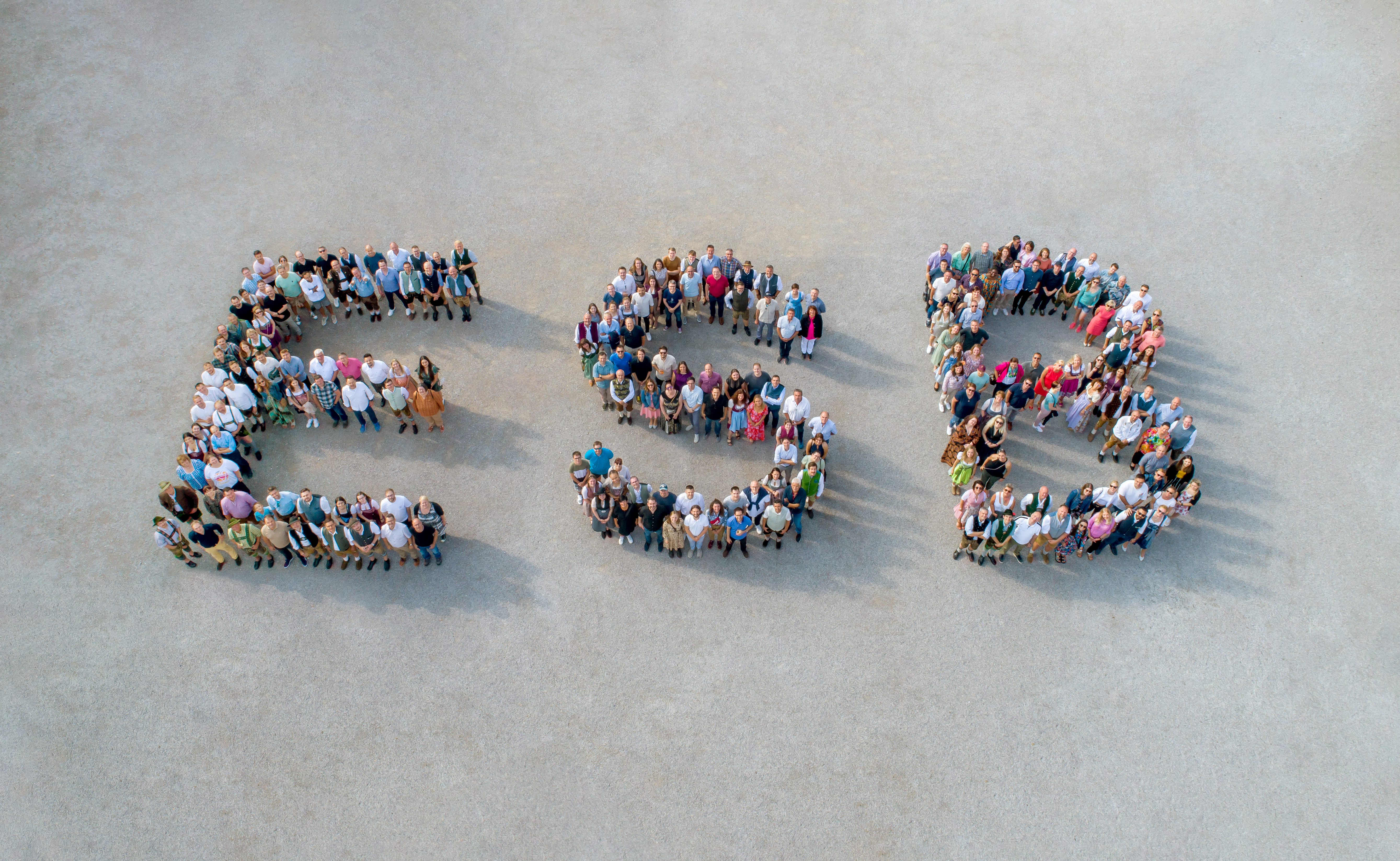 Eine große Gruppe an Menschen bildet gemeinsam die Buchstaben E S B