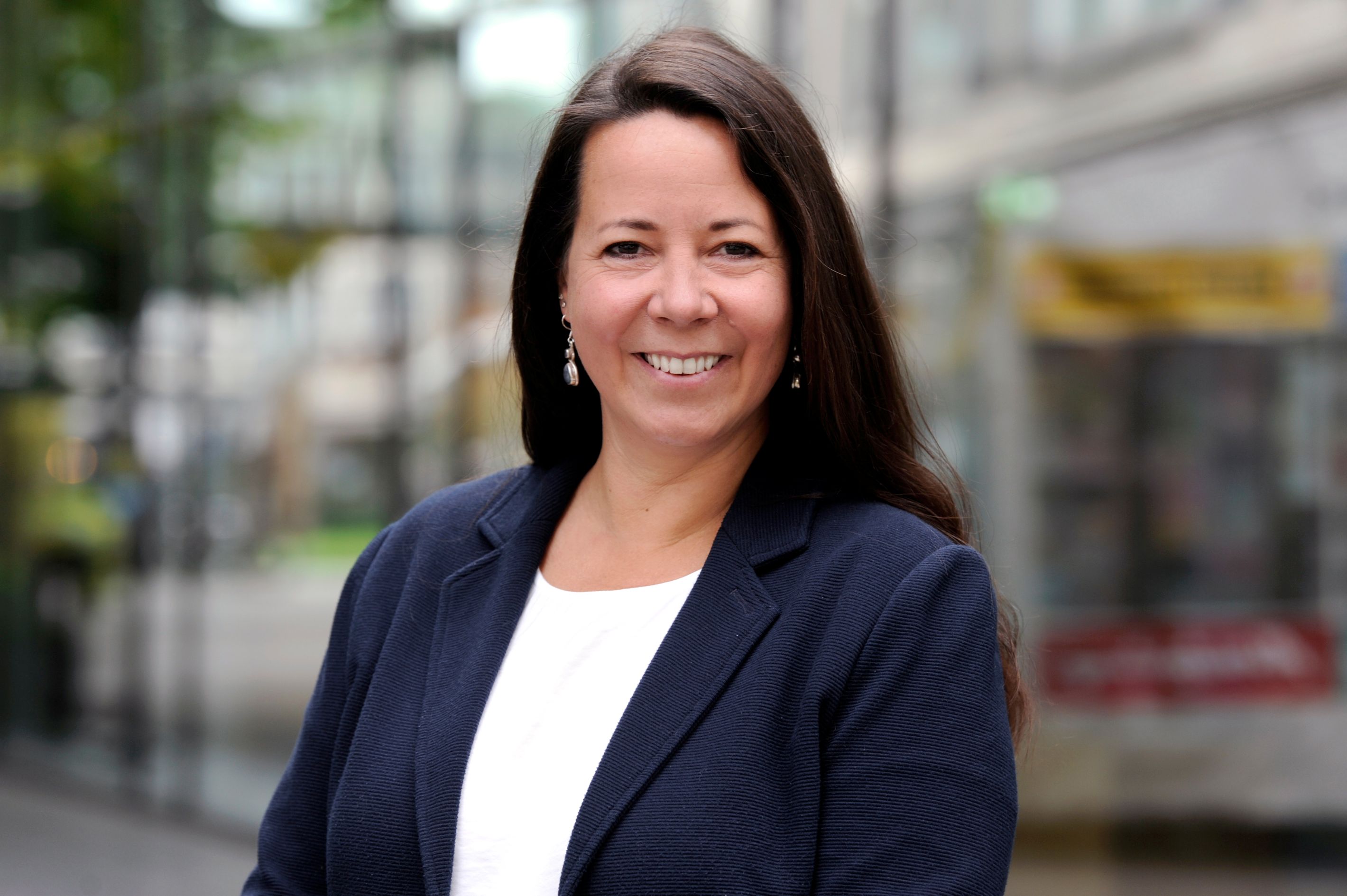 ESB Mitarbeiterin vor Glasfenster mit Bäumen im Hintergrund