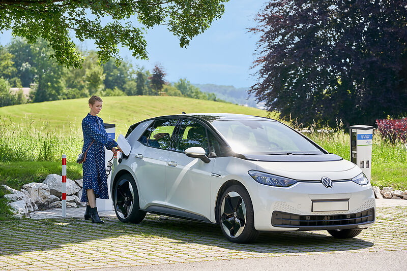Eine Frau steckt ein E-Carsharing Auto der INNergie von der INNergie Ladesäule ab.