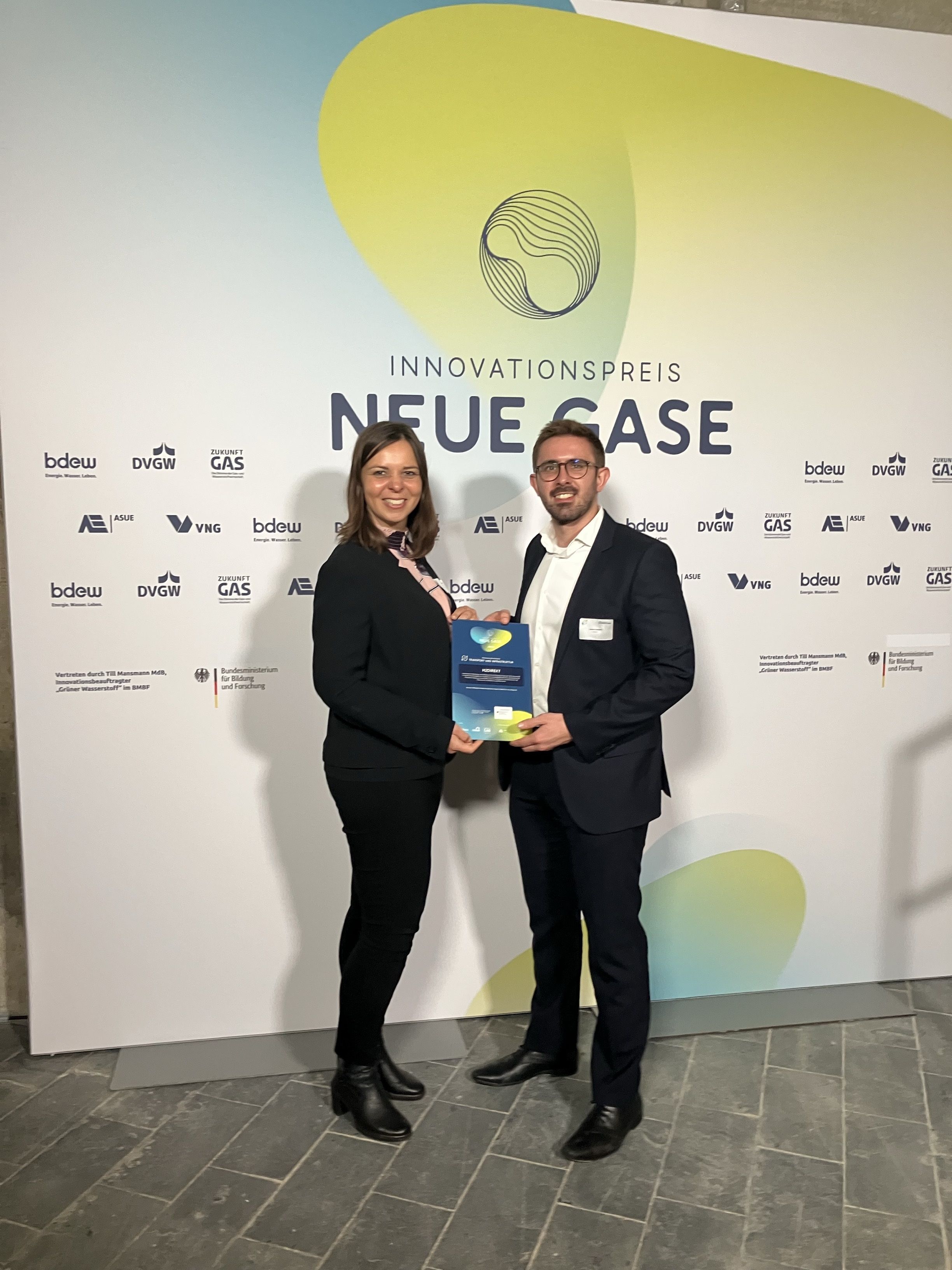 Zwei Personen halten eine Urkunde des Innovationspreises Neue Gase in der Hand.