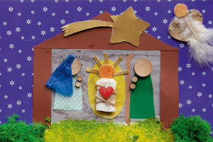 Gebasteltes Bild eines Kindes mit Maria, Josef und Jesus und einem Stall.